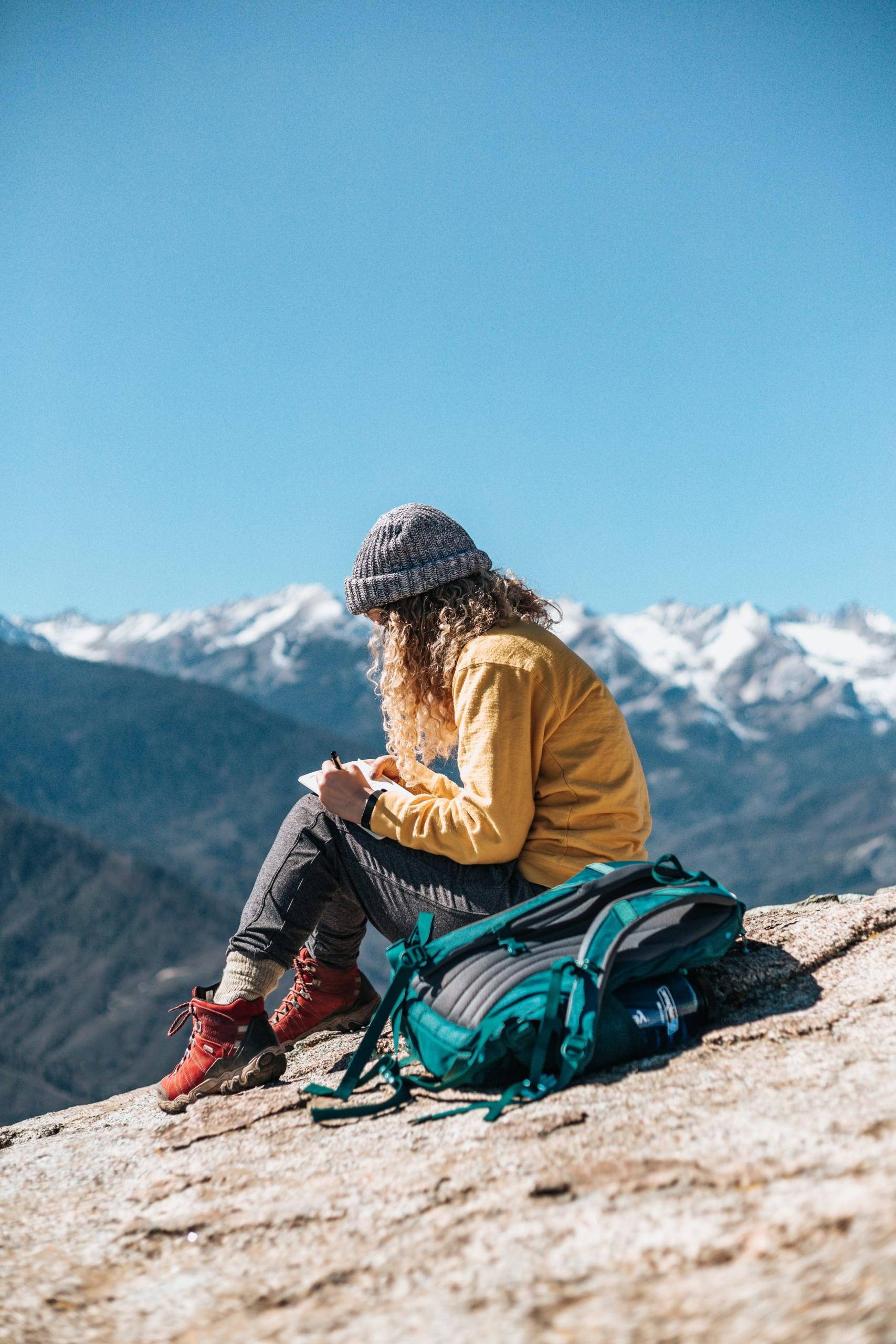 Photo of a young woman sitting somewhere in the mountains
