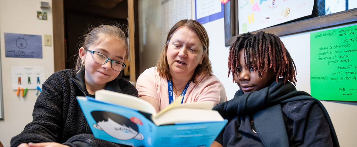 密歇根州立大学丹佛 student Patricia Formosa reading a book to children in a classroom.