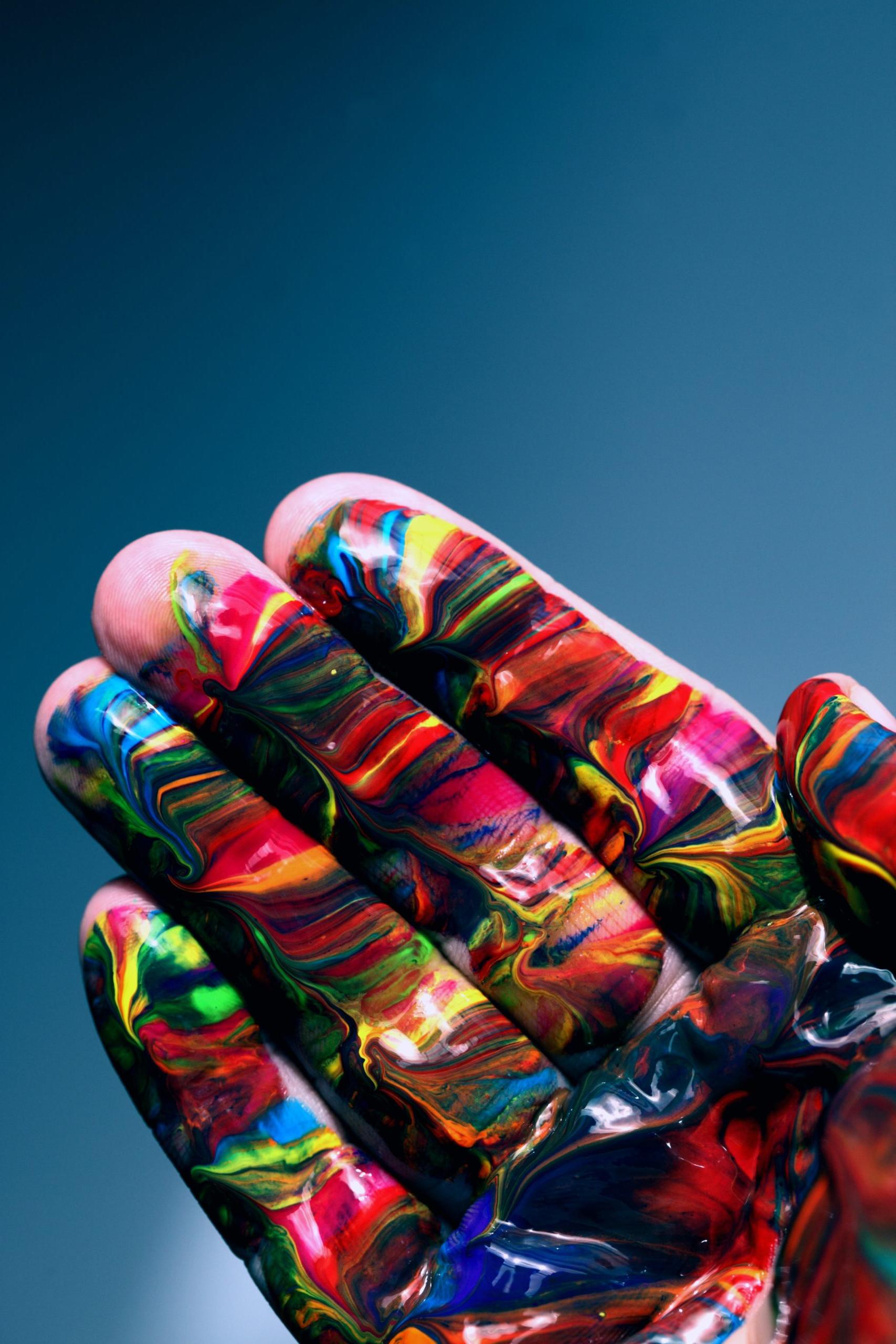 A hand with colorful paint on the fingers and palm
