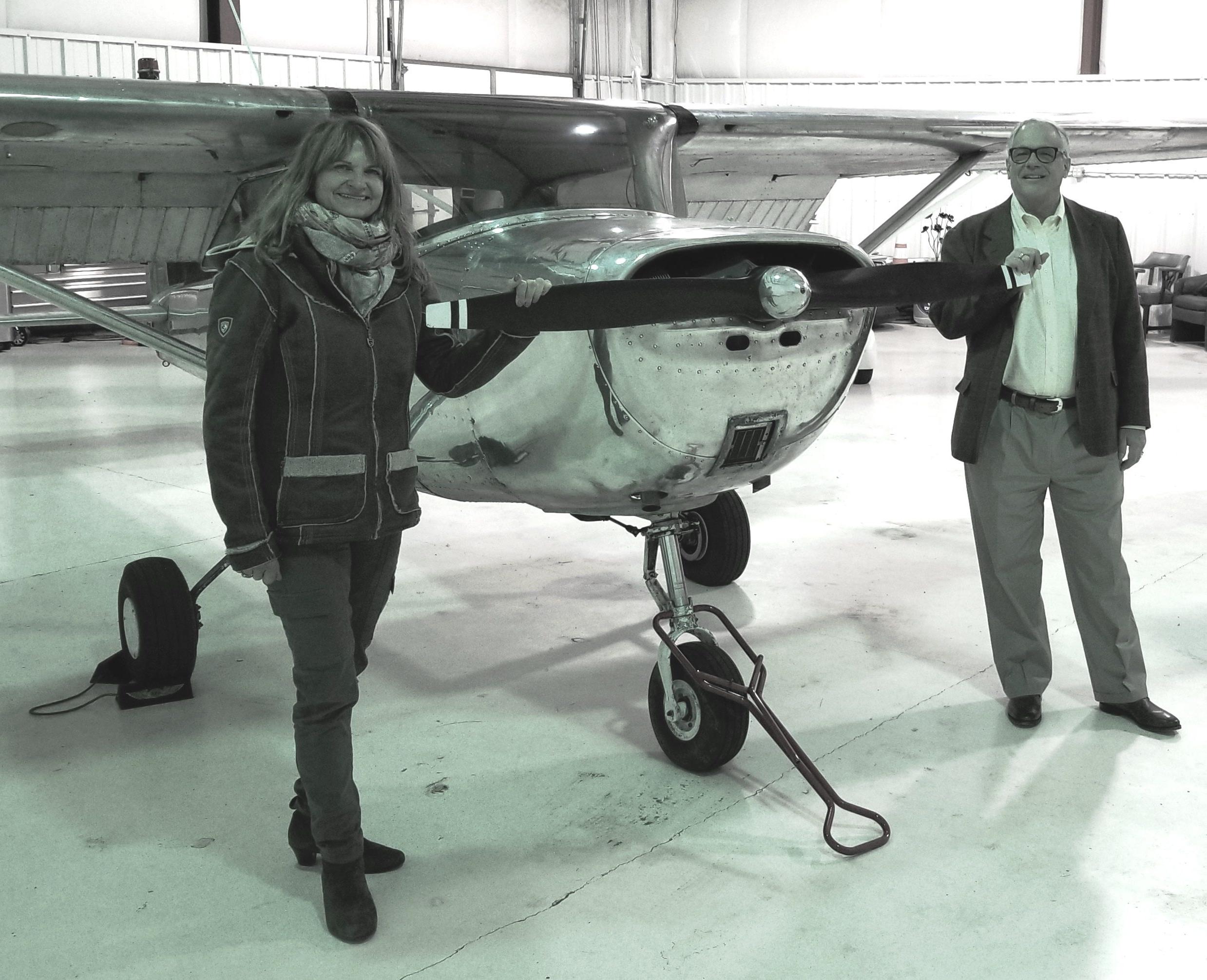 系主任博士. 杰弗里·福雷斯和教员达格玛·克雷斯站在一架单引擎飞机旁.
