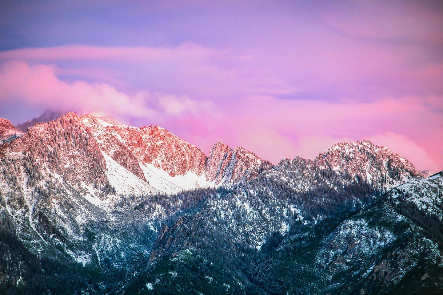 落基山脉的晚霞，粉红色的云彩笼罩在积雪崎岖的山峰上