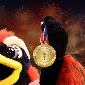 Social media profile image for Day of Giving with Rowdy holding a gold medal with fireworks in the background